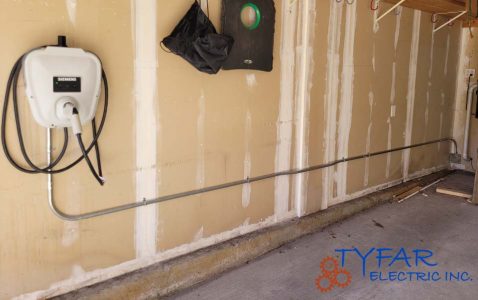 Professional garage EV charger installation with neat conduit and proper grounding. Garage EV charger installation with surface-mounted conduit by TYFAR