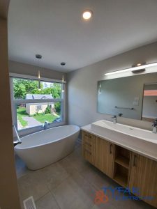 Layered bathroom lighting for comfort, visibility, and modern design. Residential bathroom with tub, vanity, and recessed lighting installed by TYFAR