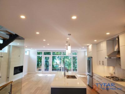 Modern recessed and feature lighting for a bright, open living space. Open-concept kitchen and living area with recessed lighting installed by TYFAR